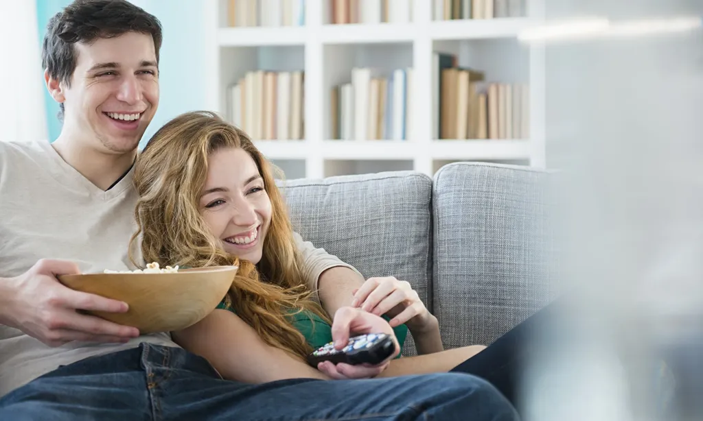 Casal vendo tv com, feliz curtindo os conteúdos da Top Play - Teste IPTV